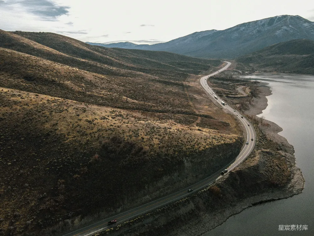 高清摄影  一条蜿蜒的道路俯瞰图，旁边是一片水域