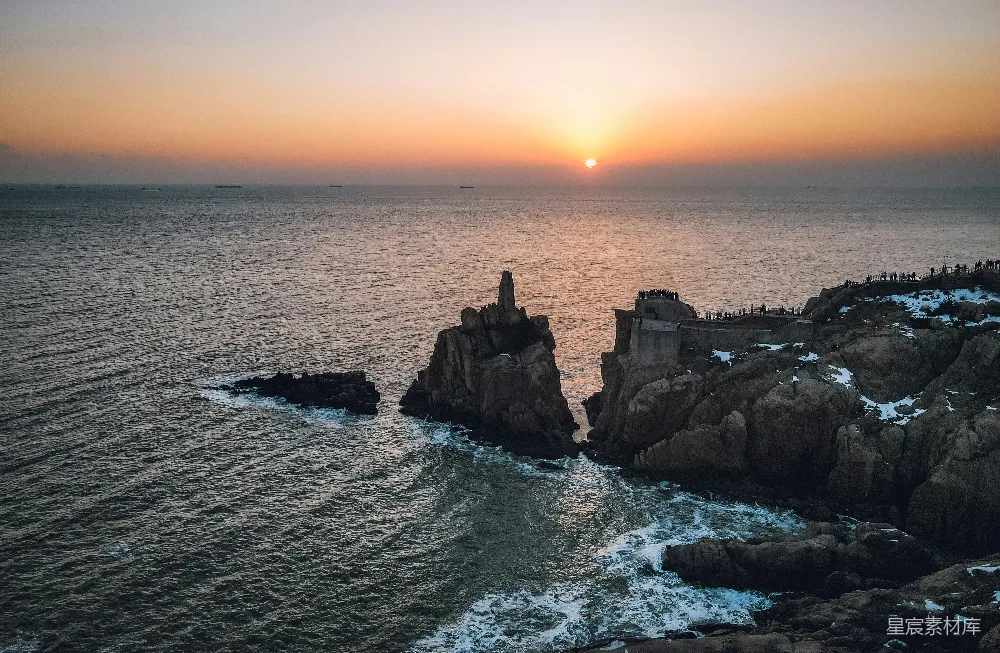 高清摄影  太阳正落在这片岩石海岸附近的海面上。
