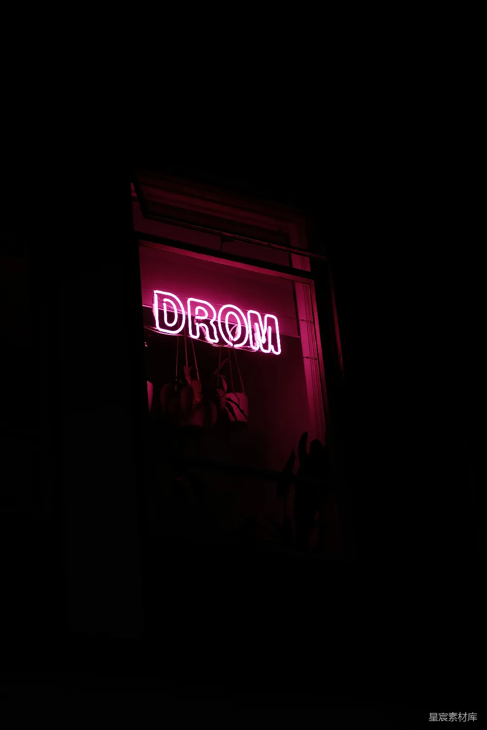 高清摄影  一盏霓虹灯，上面写着“drom”，挂在窗户上。