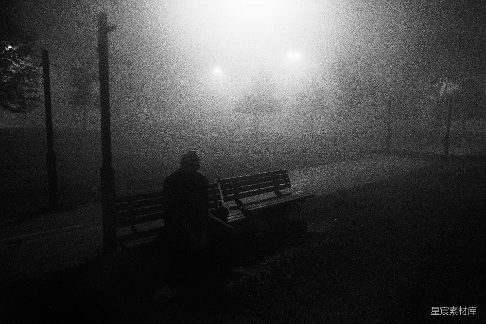高清摄影  一个坐在公园长椅上的人在夜晚