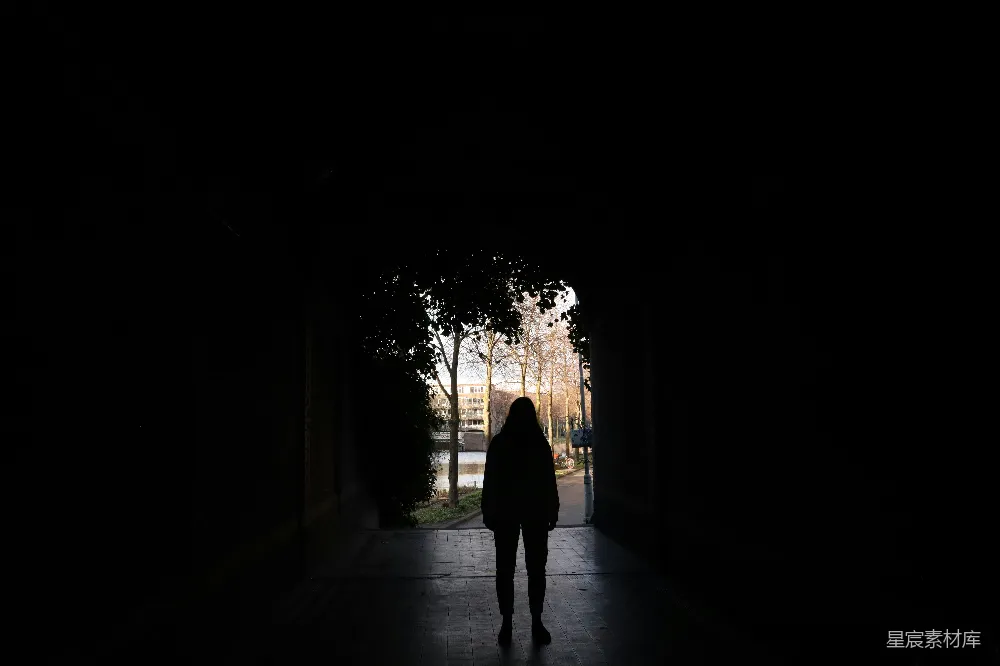高清摄影  一个人背对着镜头站在黑暗的隧道里。