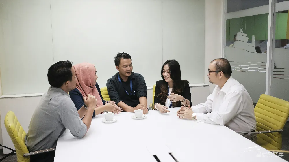 高清摄影  一群人围坐在一张白色桌子旁。