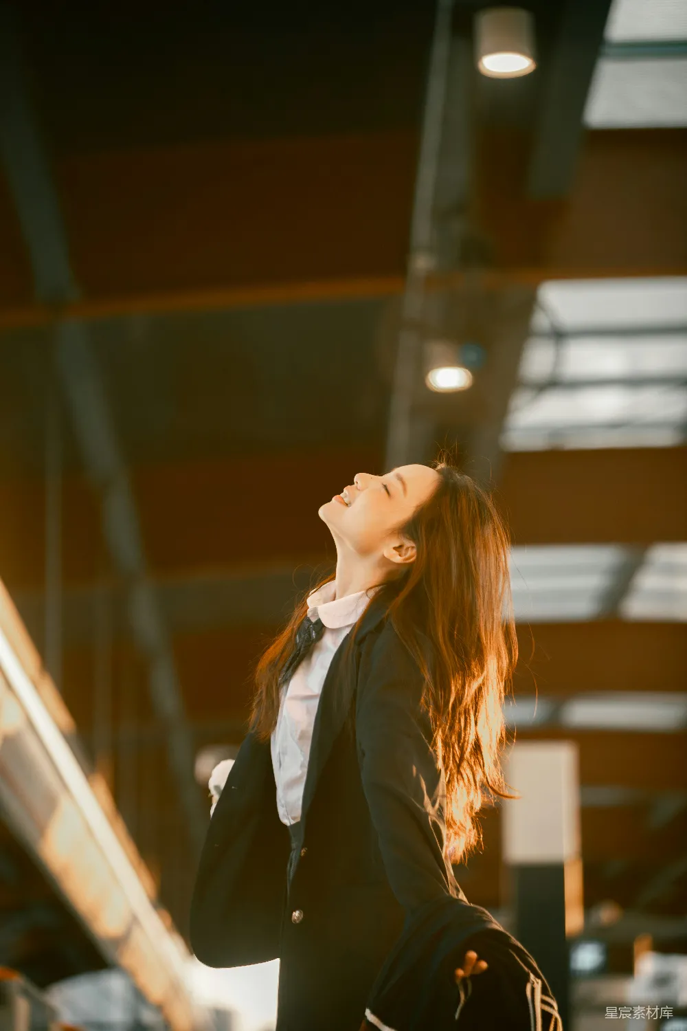 高清摄影  穿着职业装的年轻女子抬头开心地看着。