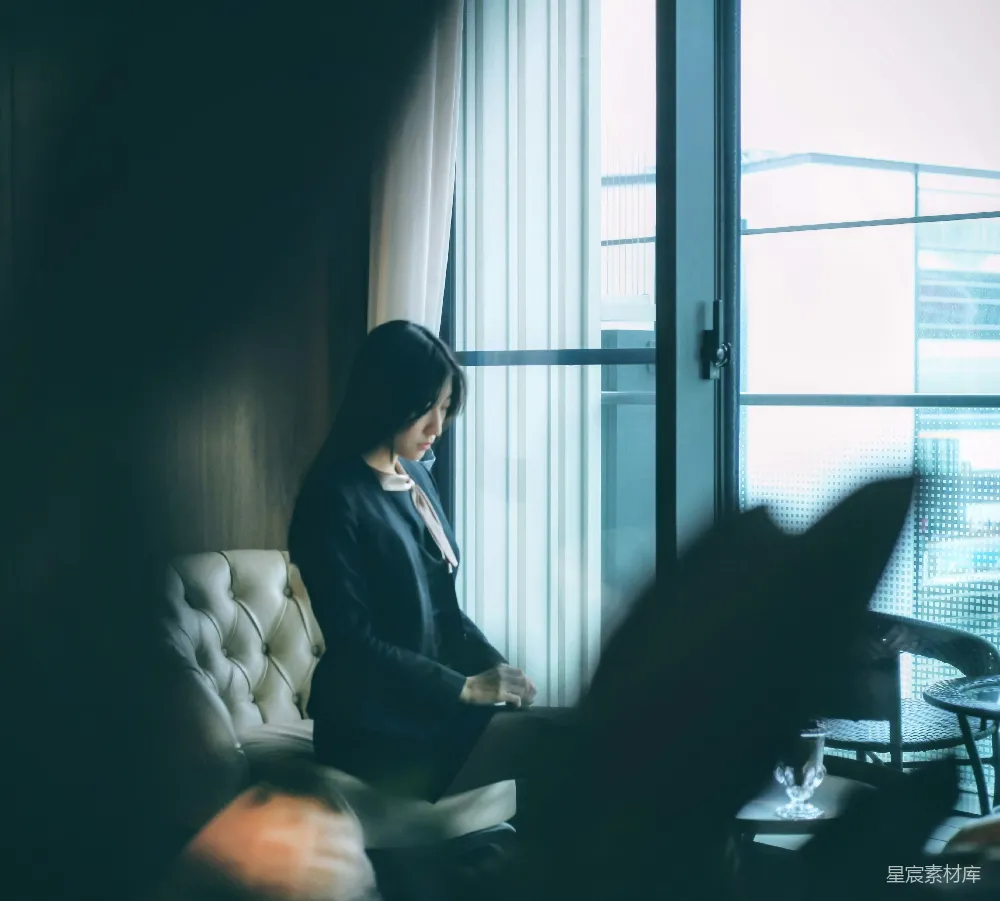 高清摄影  坐在窗户附近的椅子上的一位女士