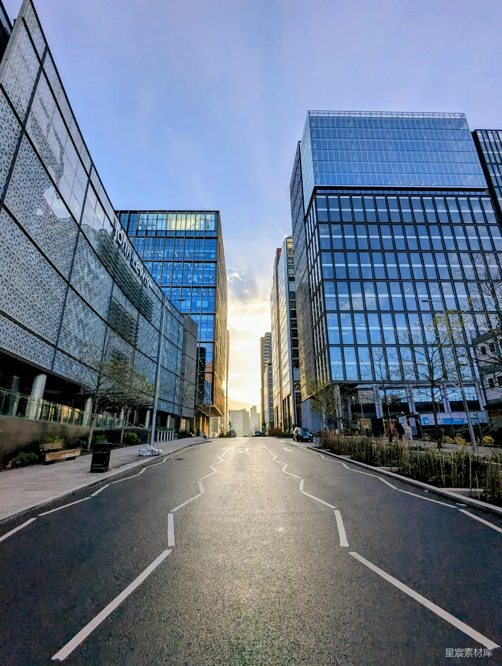 高清摄影  夕阳西下，街道两旁排列着现代玻璃建筑。