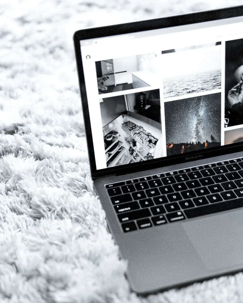 高清摄影  打开的 MacBook Pro 放在灰色地毯上