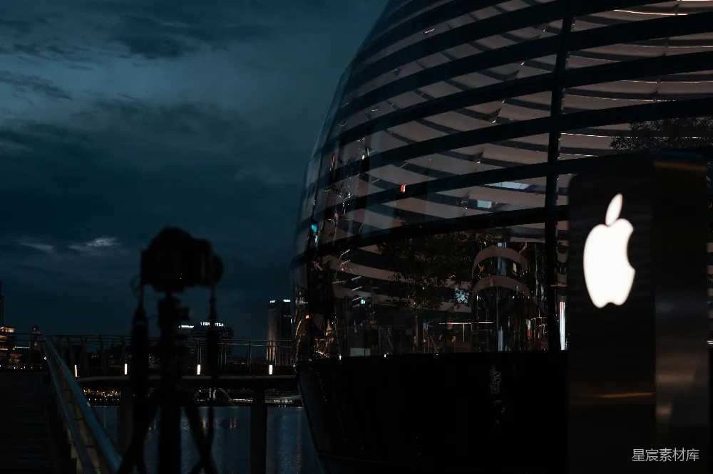 高清摄影  夜晚时分，人们站在玻璃建筑附近。