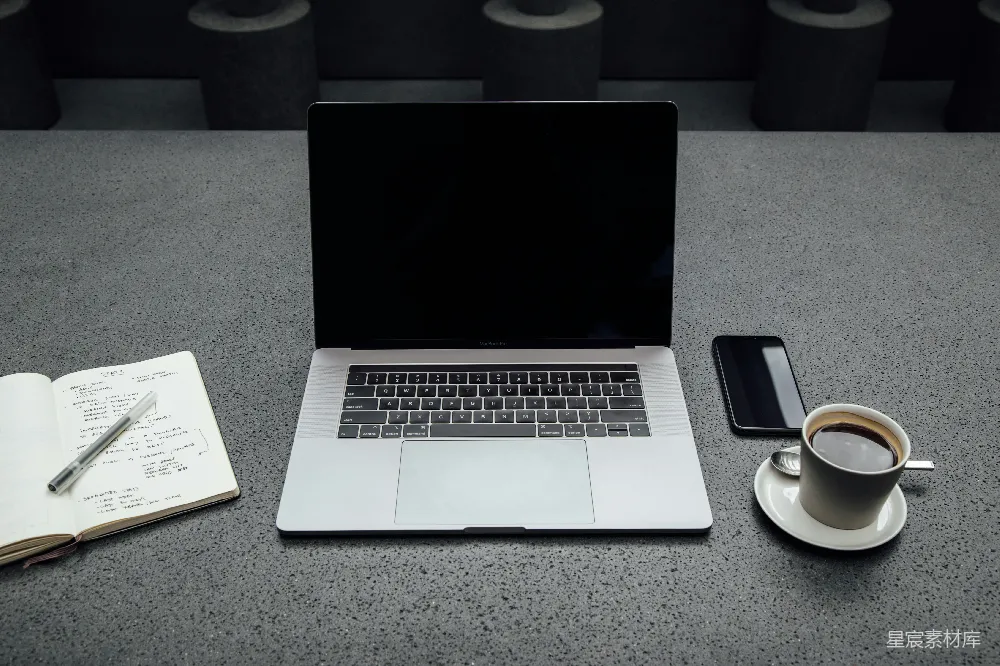 高清摄影  在咖啡杯、iPhone、笔记本和钢笔之间关闭的MacBook Pro