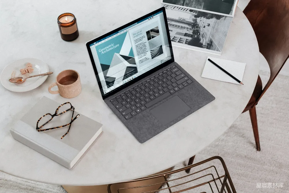 高清摄影  黑色笔记本电脑放在圆形桌子上，显示为Surface Laptop。