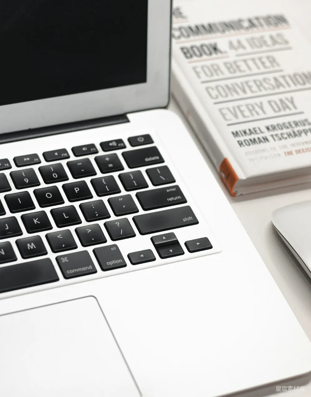 高清摄影  MacBook Air旁边有一个白色的Apple Magic Mouse。
