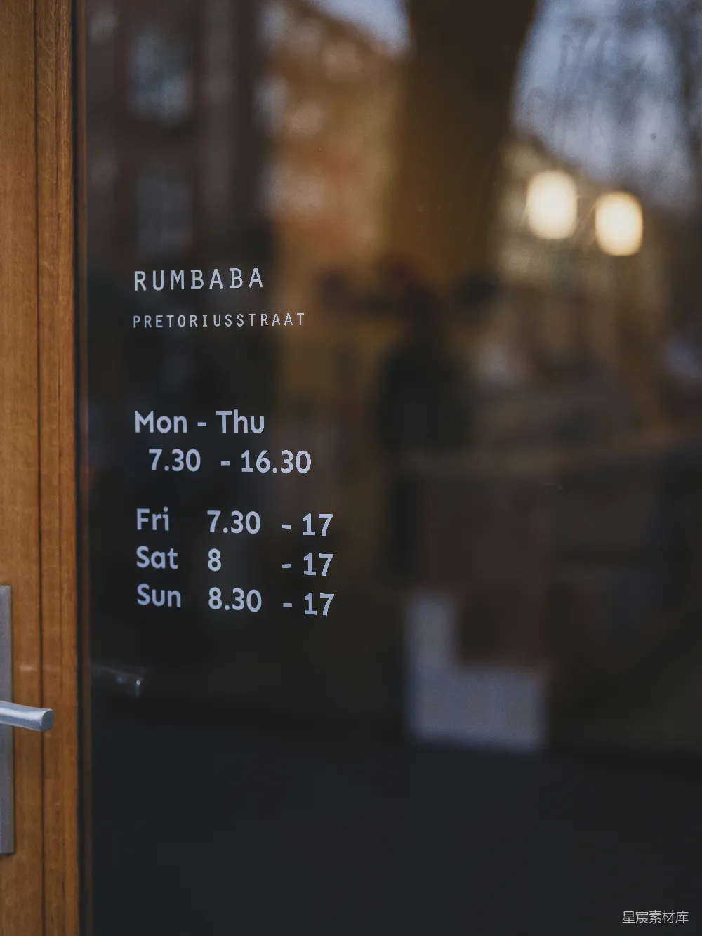 高清摄影  Rumbaba商店的营业时间显示在玻璃门上。
