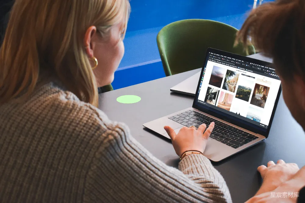 高清摄影  穿灰色毛衣的女人正在使用MacBook Pro。