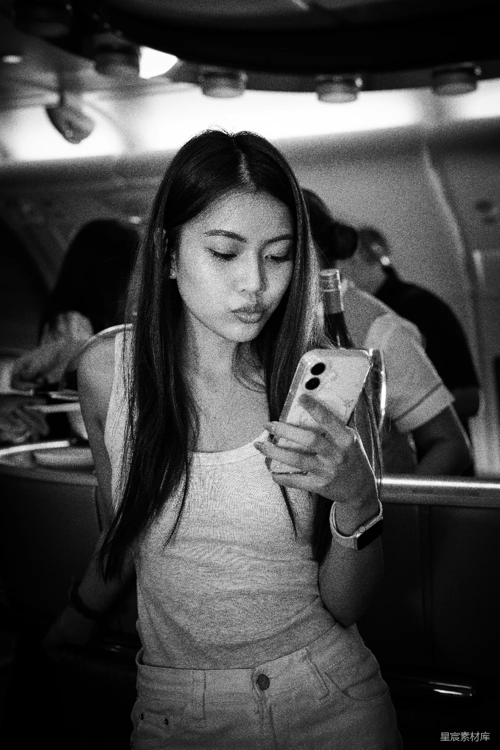 高清摄影  飞机上的女人正在看手机。