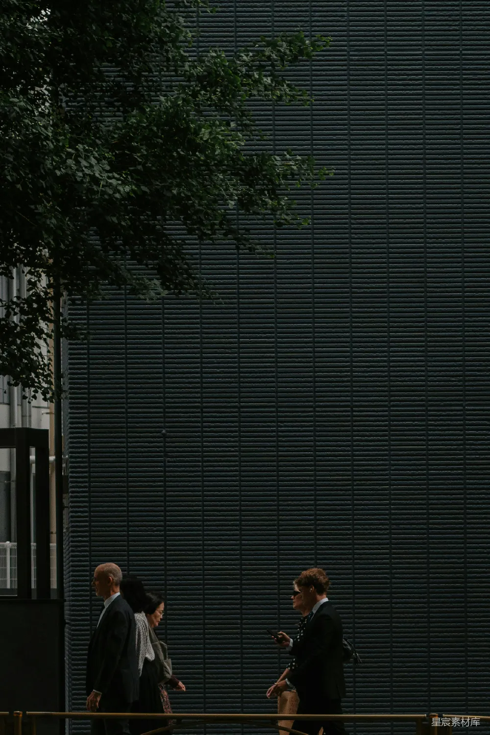 高清摄影  商人们走过一座昏暗的建筑前