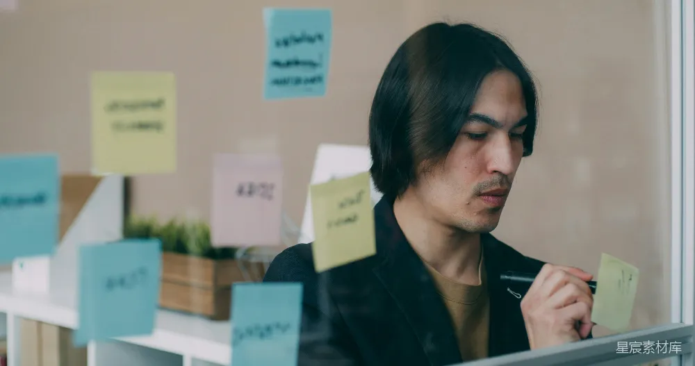 高清摄影  一个男人坐在满是便签纸的窗户前