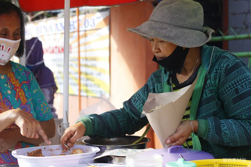 高清摄影  穿绿色和白色长袖衬衫的女人，披着绿色围裙，手里拿着一张白纸。