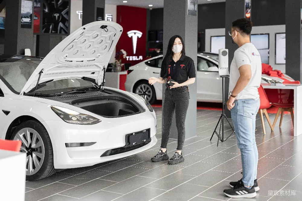 高清摄影  一对男女在展厅里看着一辆车。