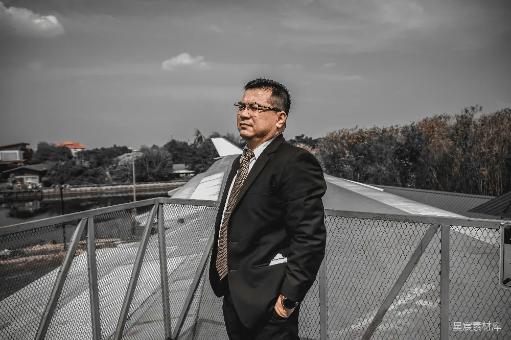 高清摄影  一个穿着西装打着领带的男人站在阳台上。
