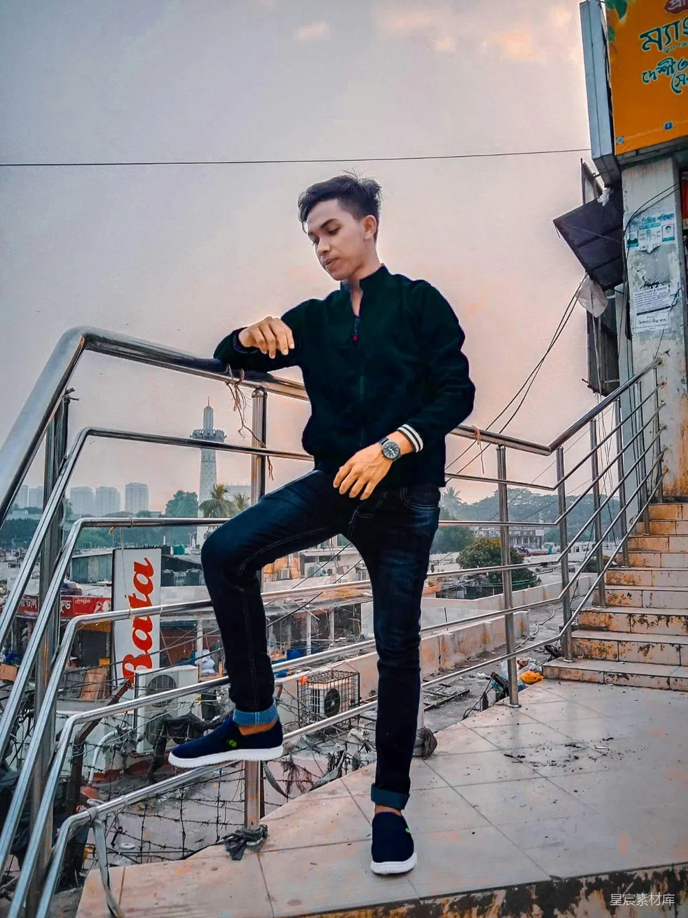 高清摄影  一个男人坐在金属护栏的顶部。