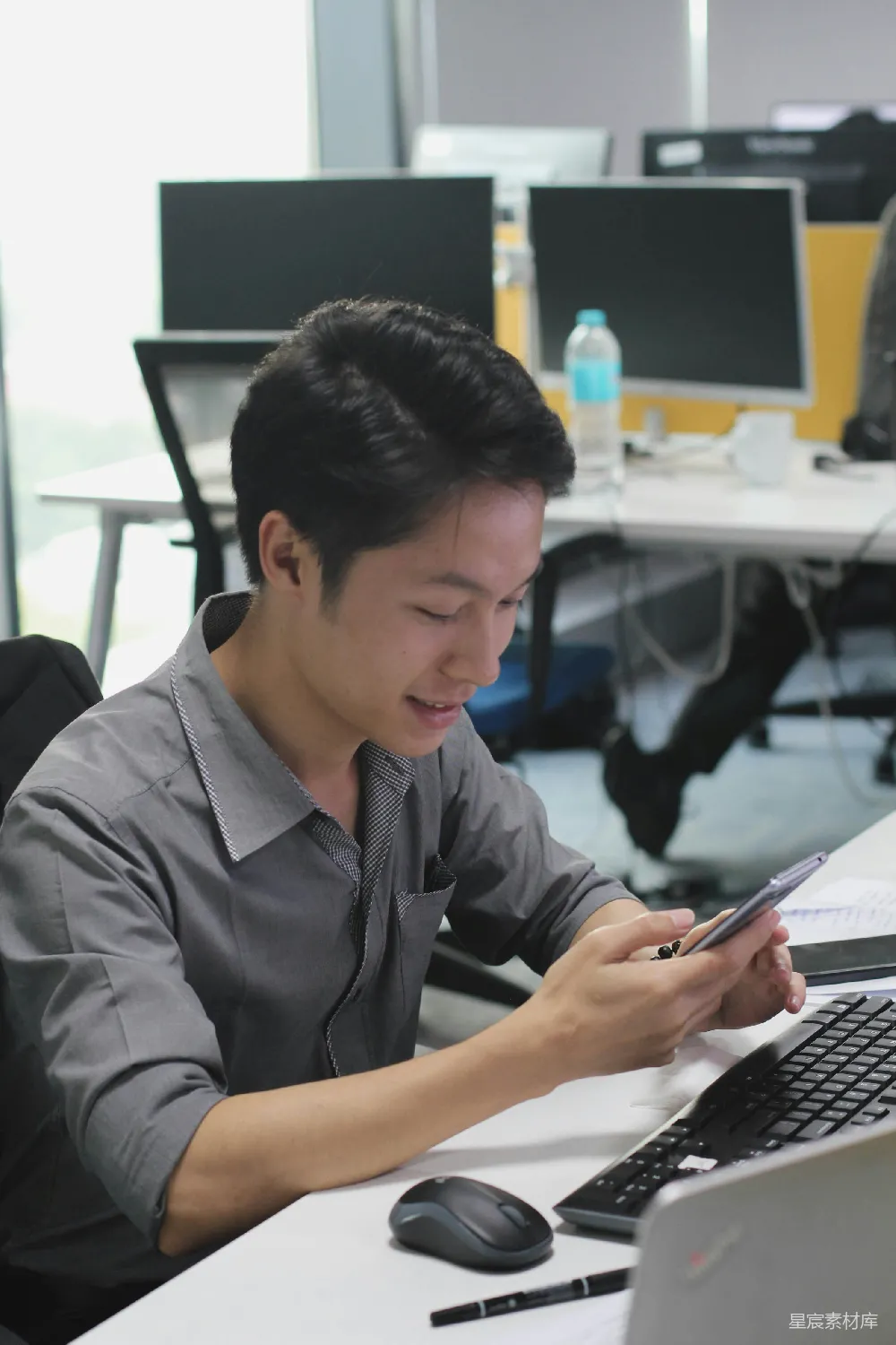 高清摄影  一个男人坐在桌子旁使用手机。