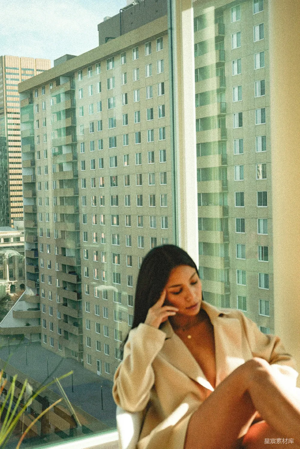 高清摄影  穿着米色外套的女人站在玻璃墙旁边