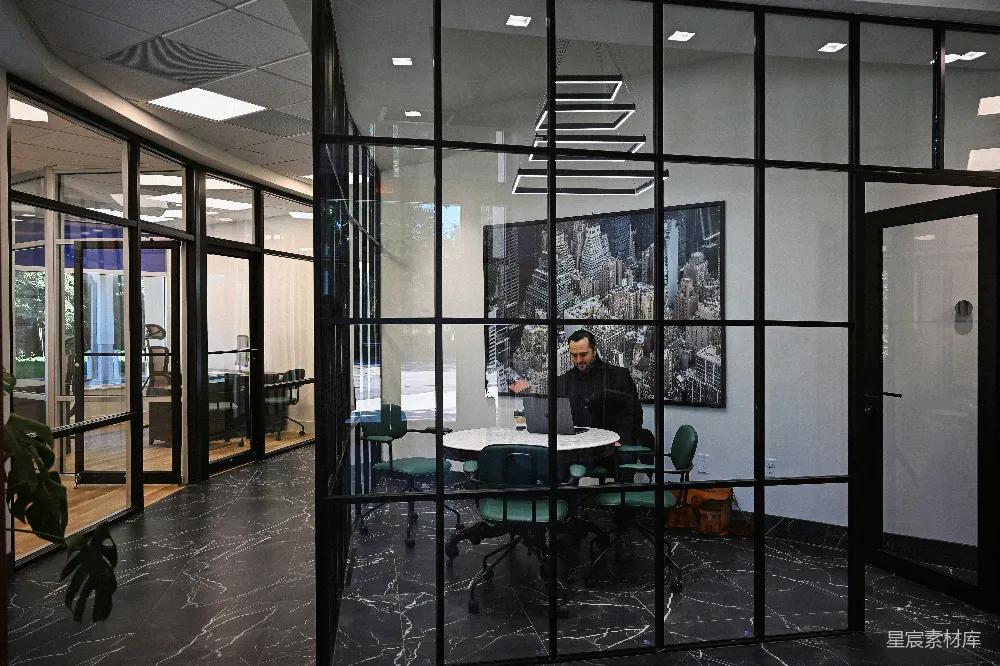 高清摄影  在现代化的办公室会议室里，一名男子正在使用笔记本电脑工作。
