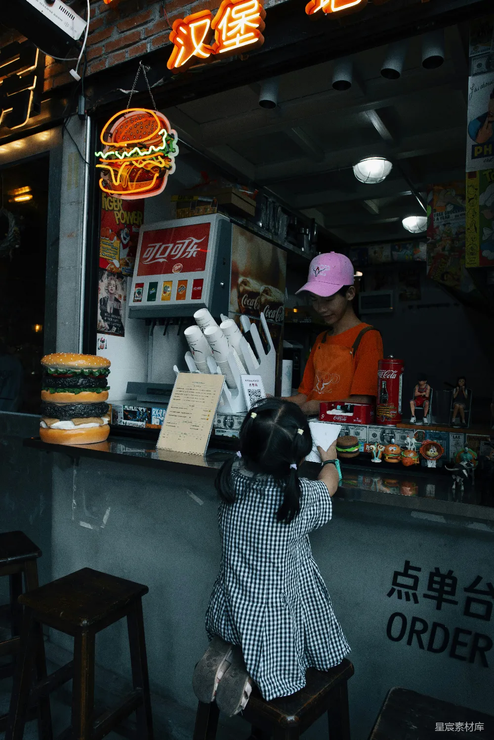 高清摄影  一个小女孩站在一家快餐店前面。