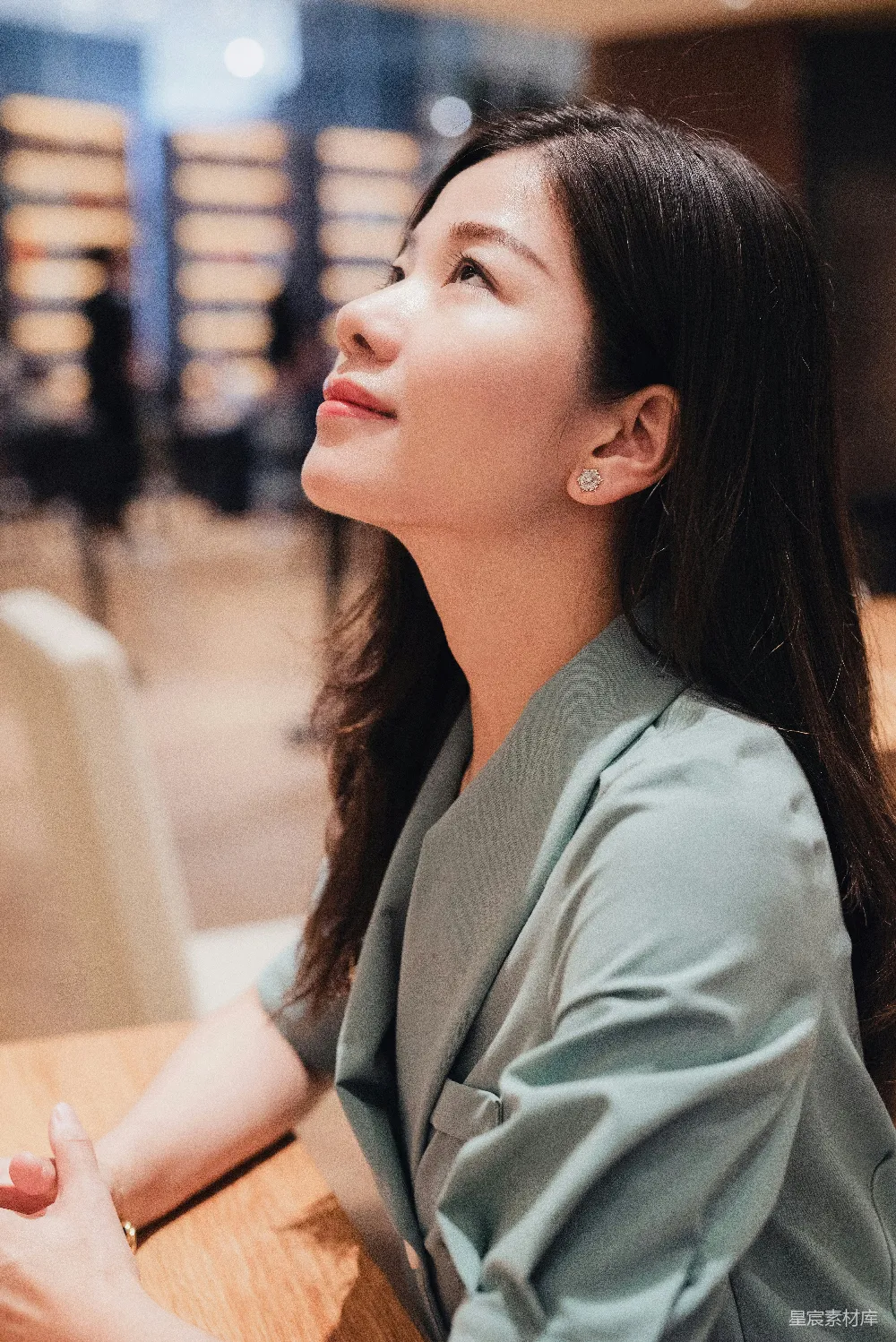 高清摄影  一位女士坐在桌前抬头看。