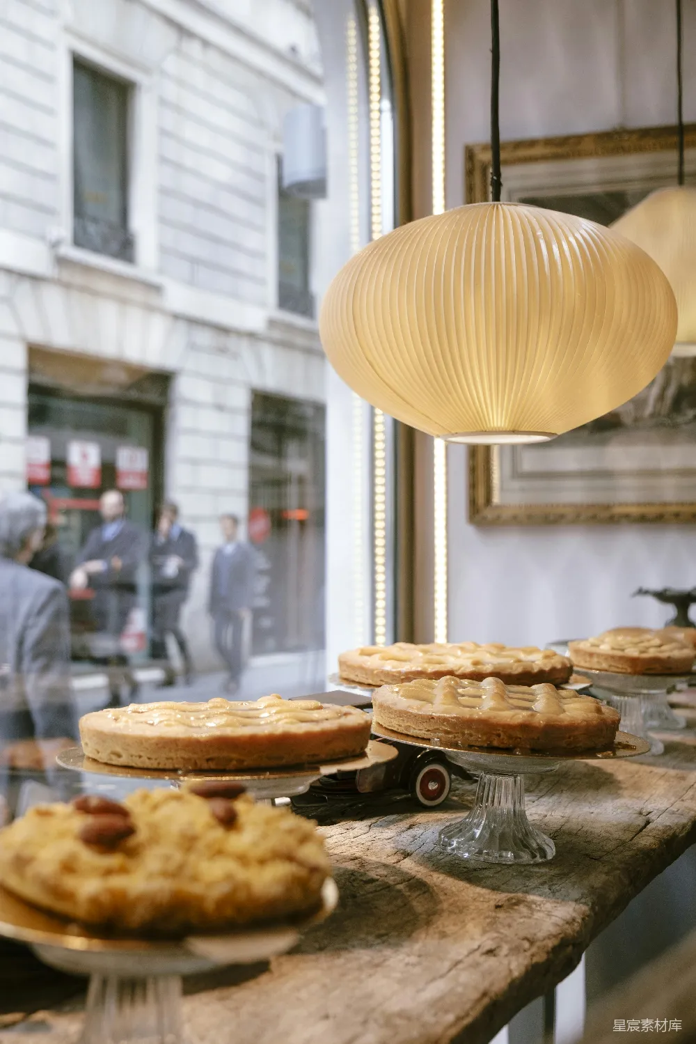 高清摄影  圆形白色吊灯悬挂在展示的各种蛋糕上方