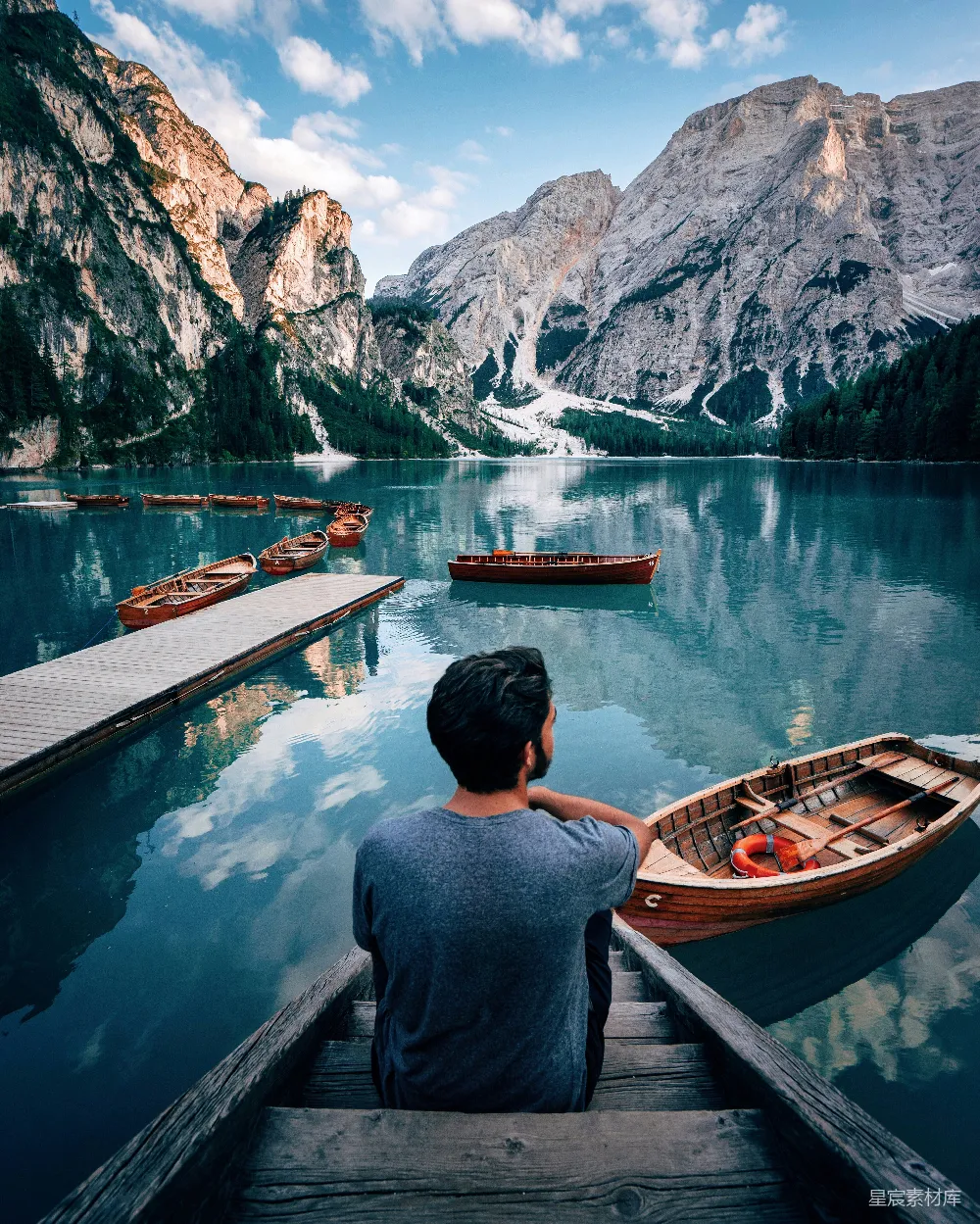 高清摄影 自然 一个男人坐在棕色木制楼梯上，凝视着白天山间附近的湖泊。