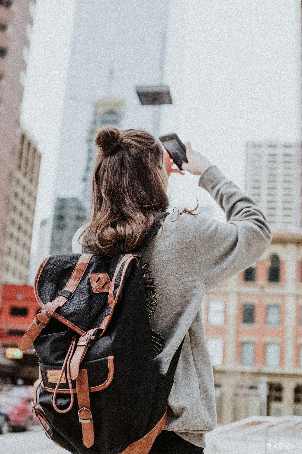 高清摄影 自然 女人正在路边拍摄高楼的照片。