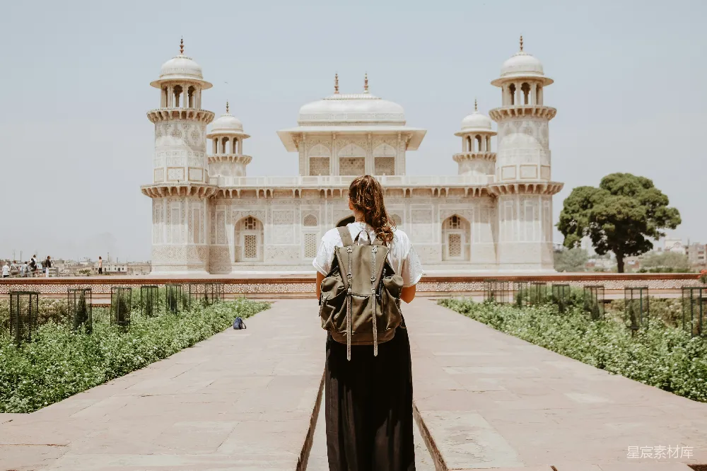 高清摄影 自然 旅行 一位女士在米色油漆的建筑附近。