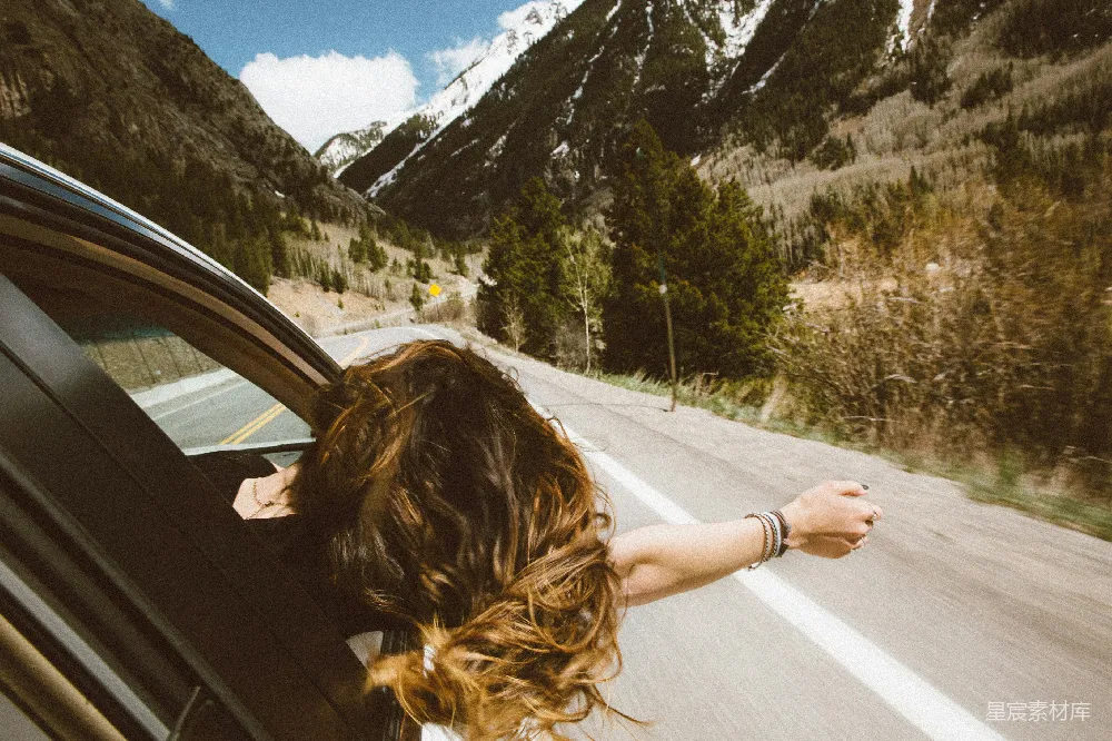 高清摄影 自然 旅行 女人在车上旅行时，把头和右臂伸到窗外。