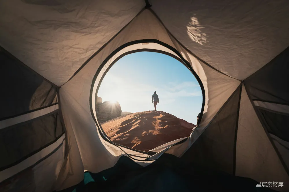 高清摄影 旅行 一个男人站在帐篷里，望向远方。
