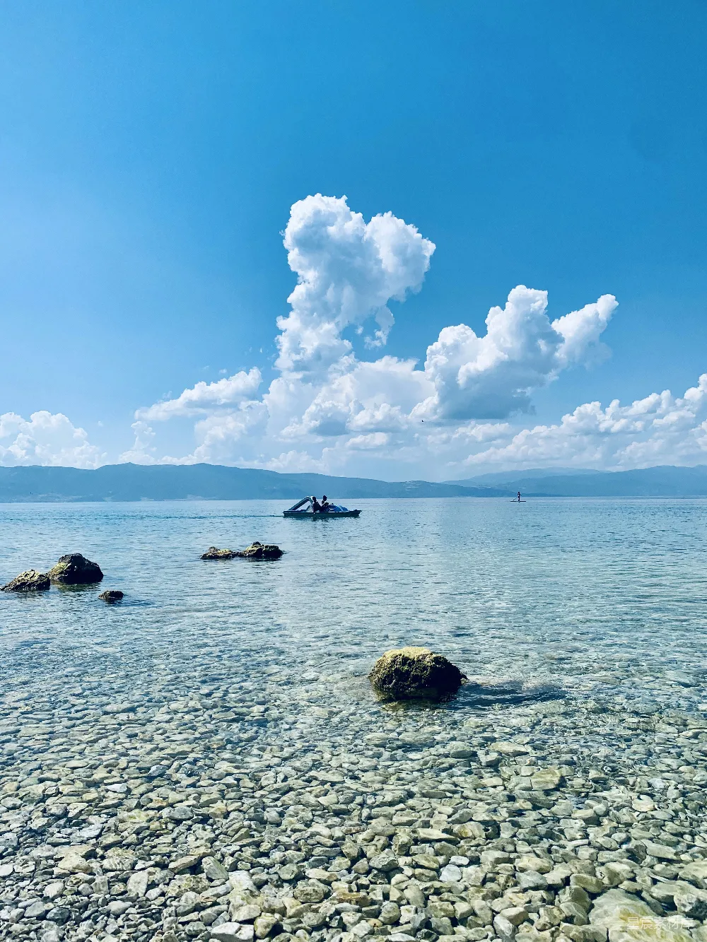 高清摄影  白天晴朗的蓝天底下，人们在海里游泳。