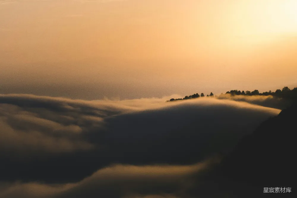 高清摄影 壁纸 自然 夕阳正从山峦中的云层后落下。