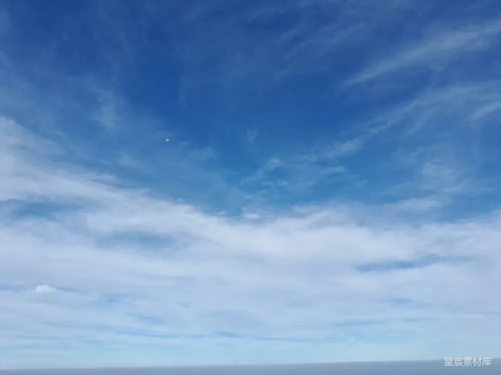 高清摄影  一个男人站在海滩上，手里拿着冲浪板。