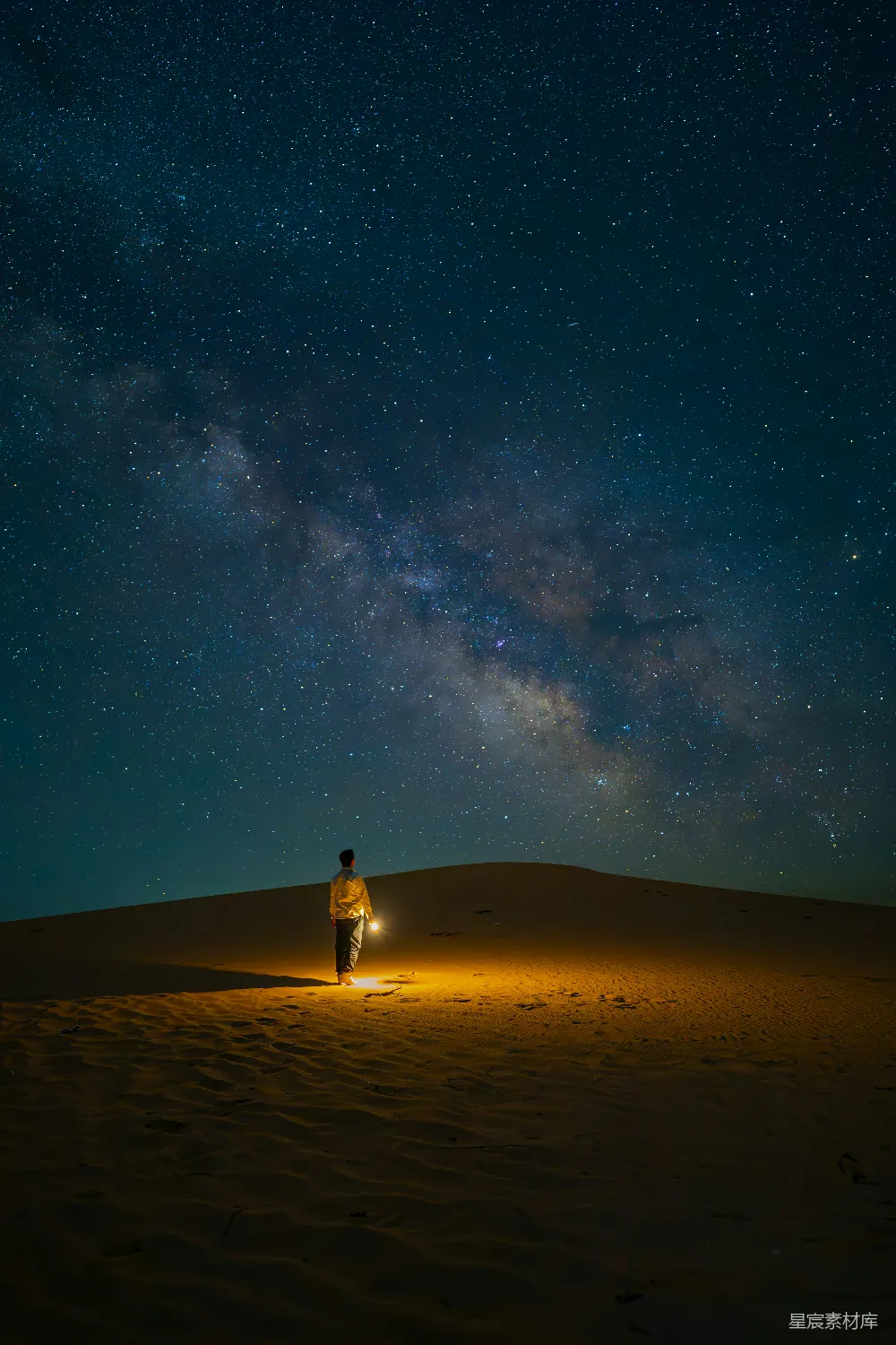 高清摄影 自然 旅行 一个男人站在一个沙丘顶部，头顶上是充满星星的夜空。