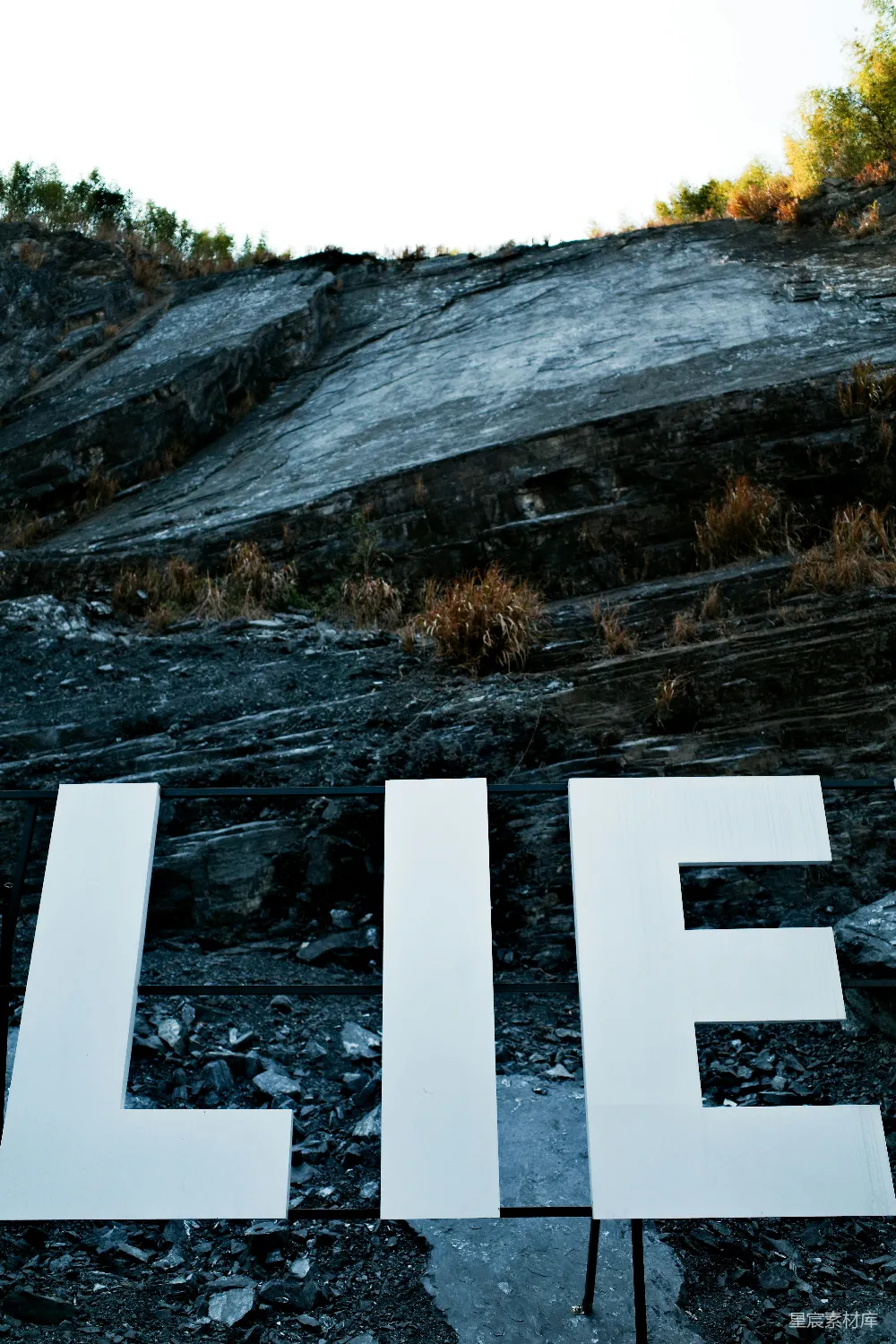 高清摄影  “lie”这个词被显示在一片荒凉的风景中。