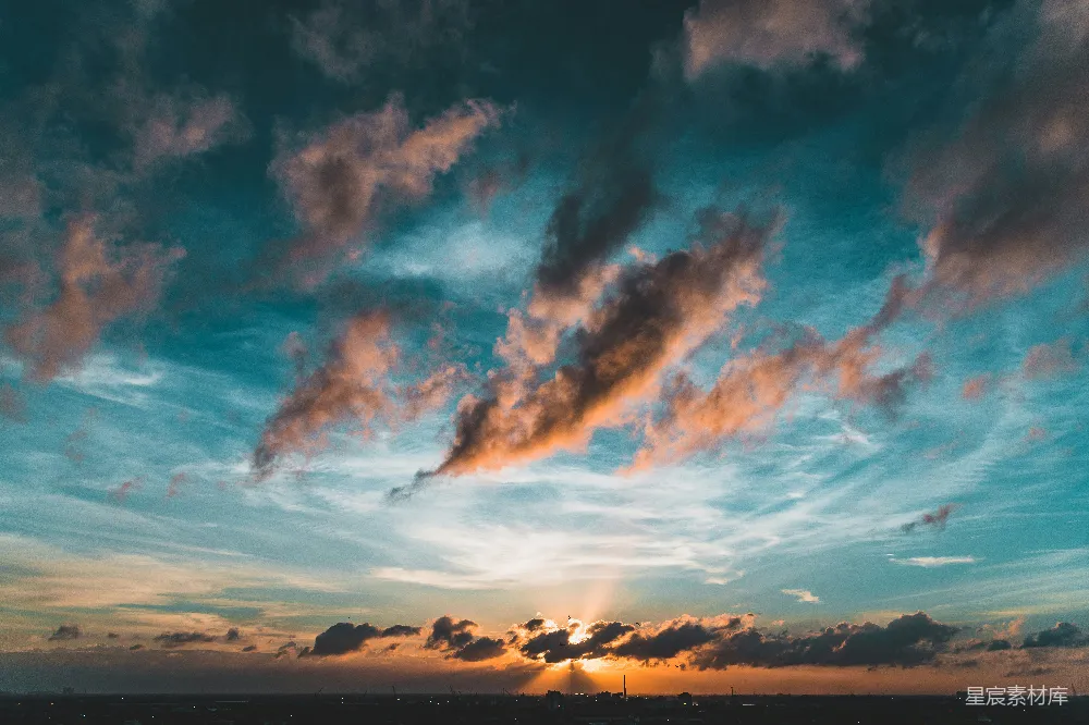 高清摄影  太阳正缓缓落海，天空中漂浮着云朵。