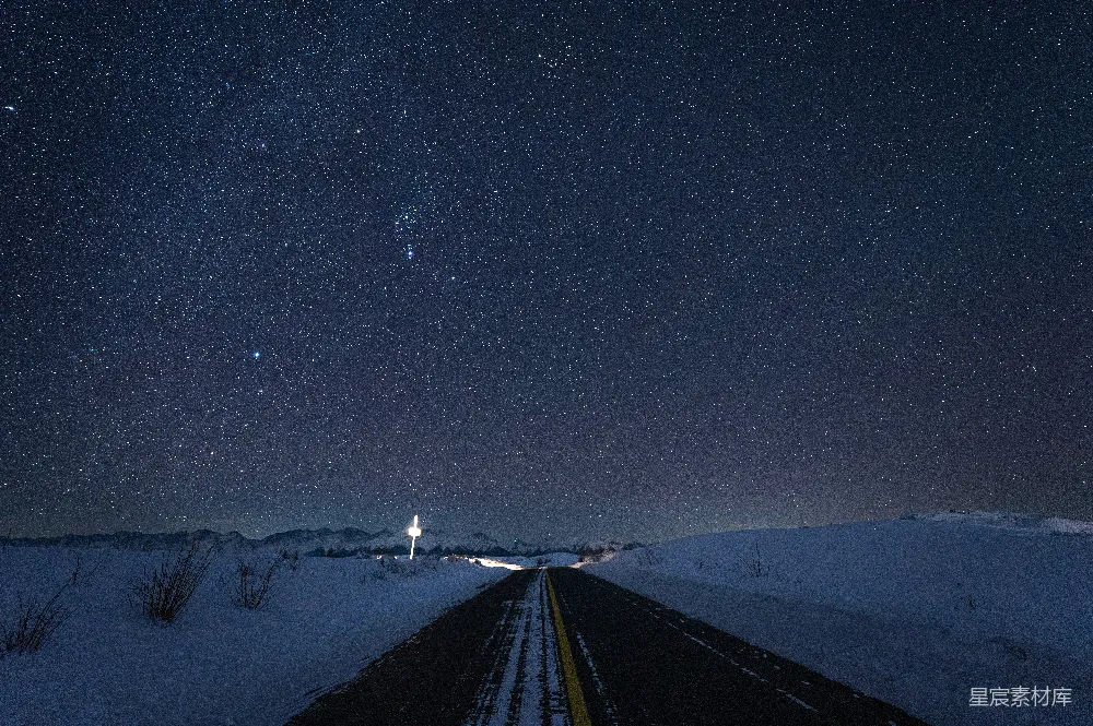 高清摄影  一条覆盖着雪的路，天空中满是星星。