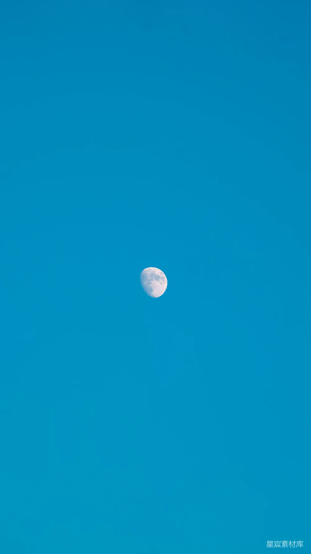 高清摄影  一片清澈的蓝天，挂着一轮半圆的月亮。