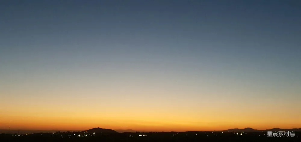 高清摄影  夕阳西下，城市在群山的背景中。
