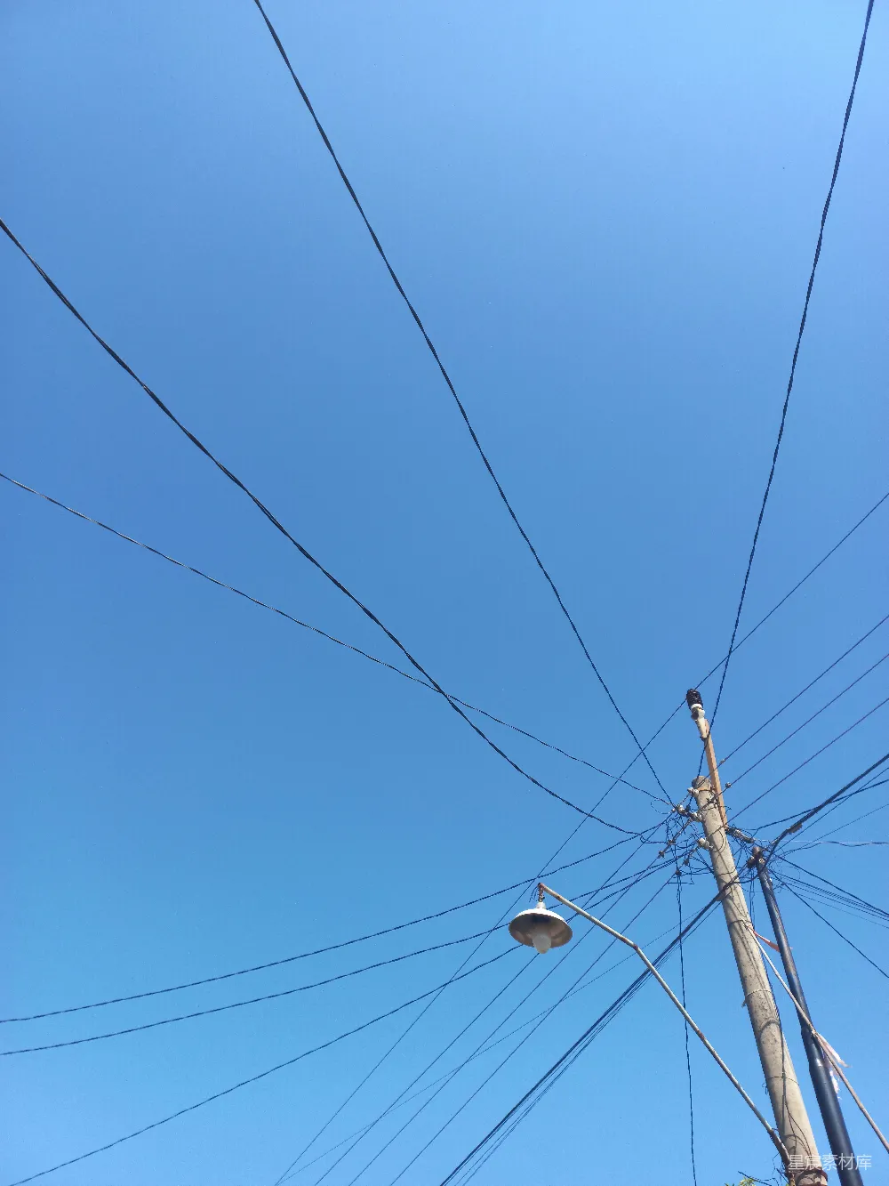 高清摄影  一根电线杆和一盏路灯在蓝天背景下。