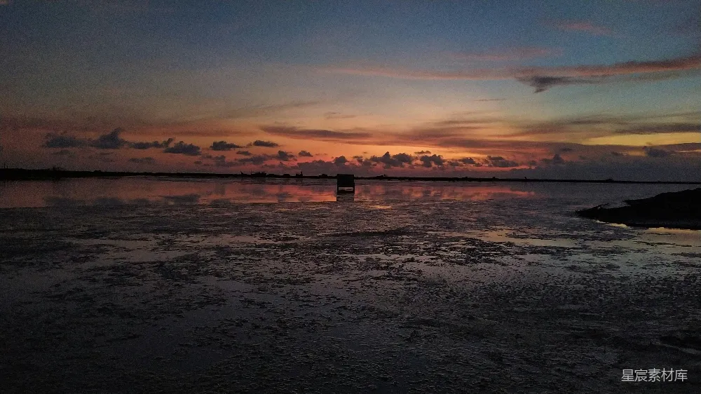 高清摄影  剪影中的人站在海码头上，背景是夕阳。
