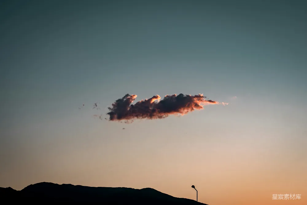 高清摄影  天空中一座山丘上方的一朵云