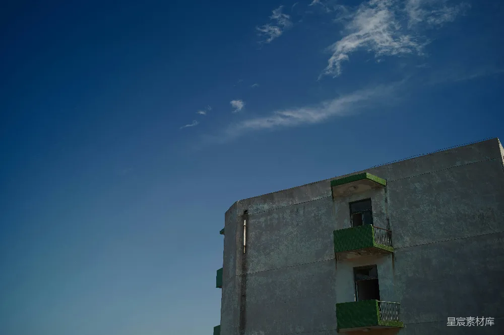 高清摄影  一座高大的建筑物，绿意盎然的阳台在蓝天之下。