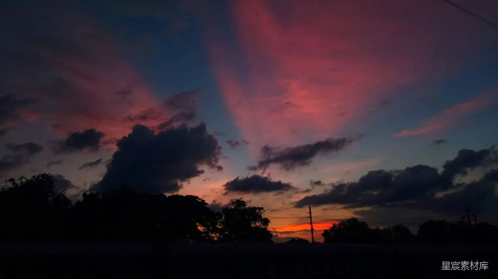 高清摄影 自然 夕阳西下，背景中有云和树木。