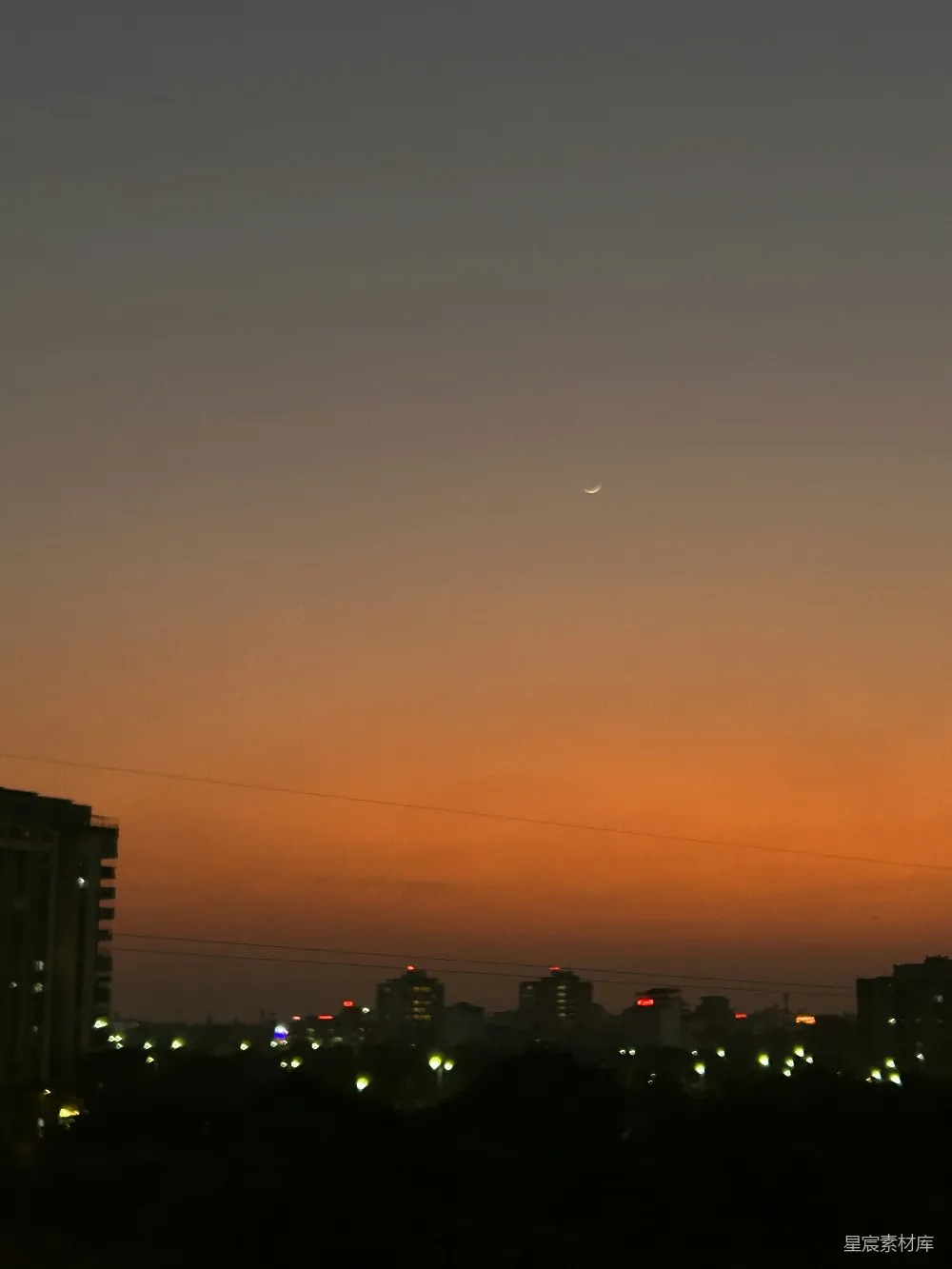 高清摄影  夜晚城市的景象，一架飞机在空中飞行。