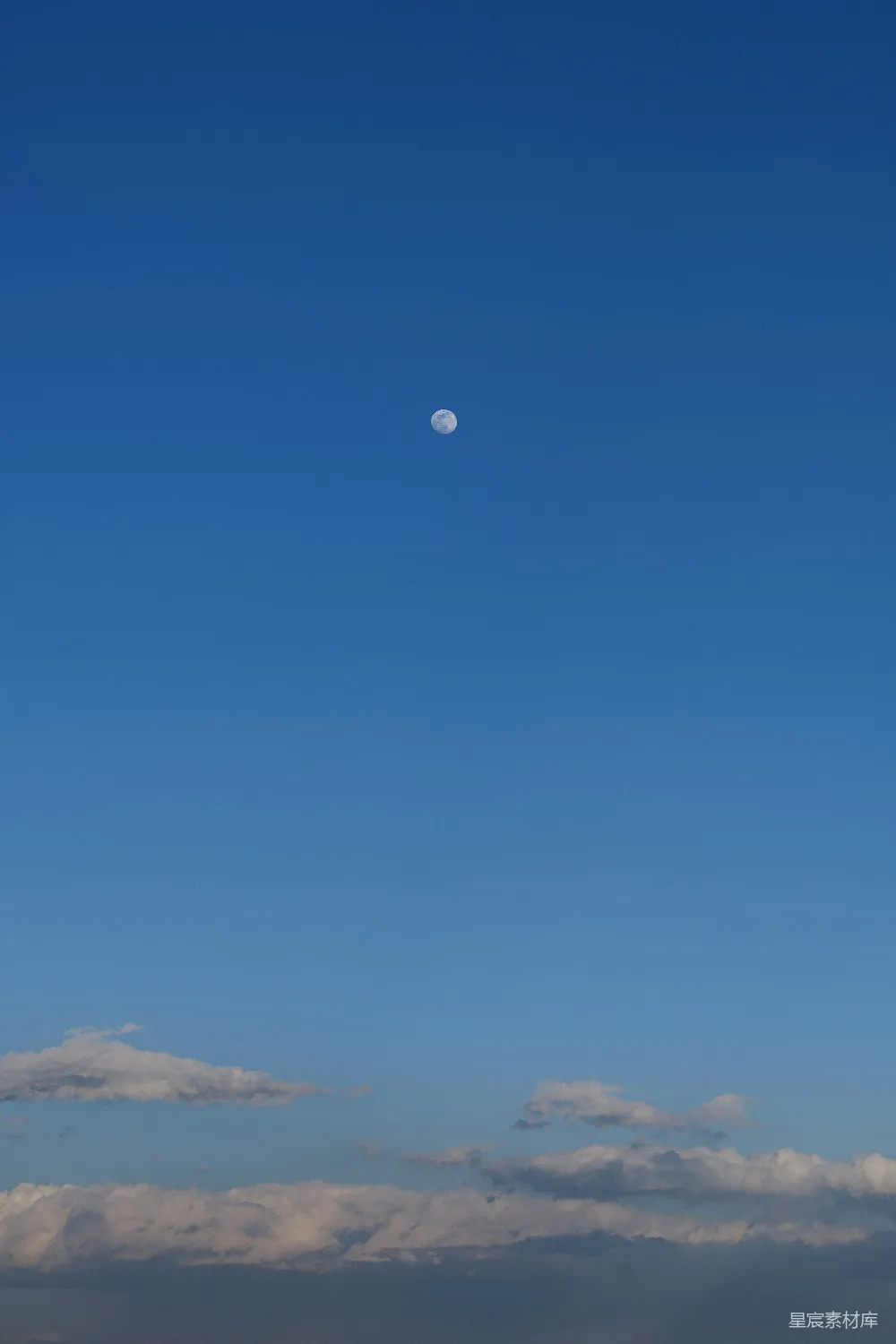 高清摄影  一架飞机在空中飞行，背景中有月亮。